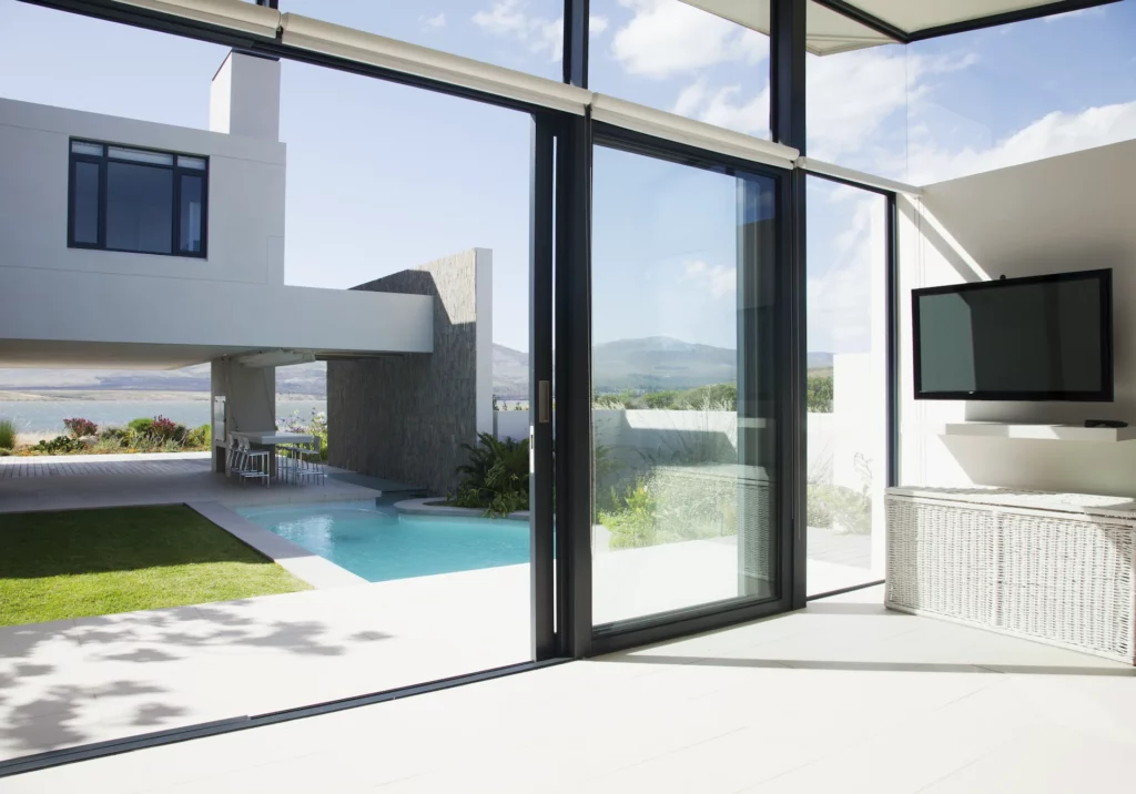 Intérieur contemporain ouvert sur une piscine par de grandes portes vitrées coulissantes