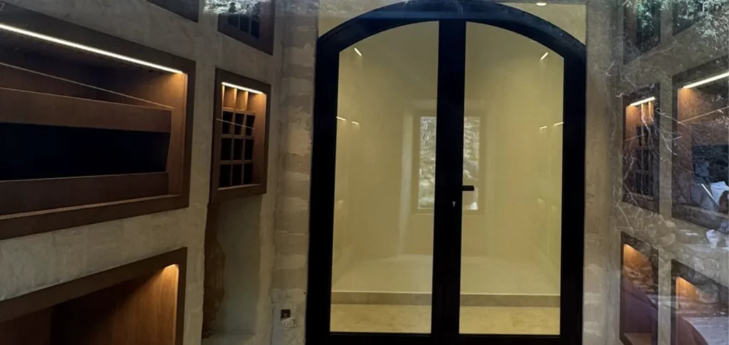 Entrée contemporaine avec une grande porte vitrée à cadre sombre et des rangements intégrés.